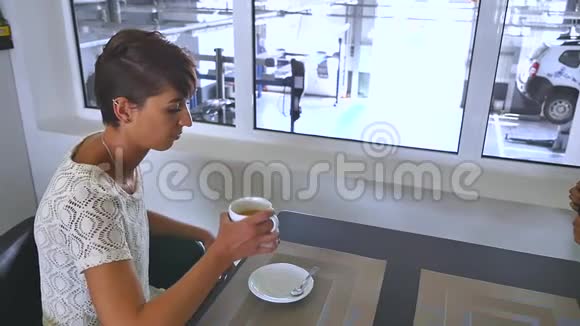 一位年轻漂亮的女士在轮胎试衣间喝咖啡视频的预览图