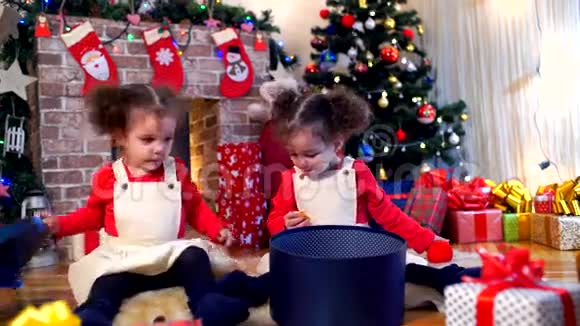 两个戴着圣诞老人帽子的小女孩坐在地上视频的预览图