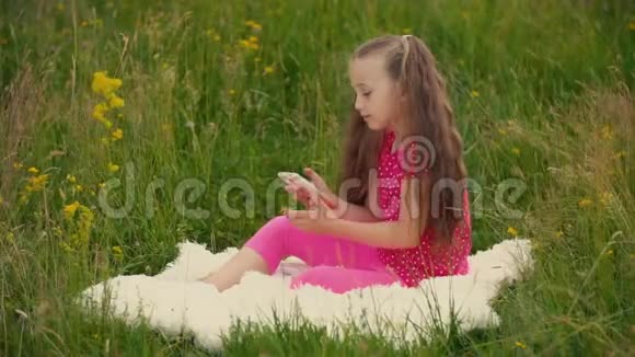带着电话坐在大自然中的女孩视频的预览图