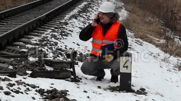 铁路工人有文件在铁路附近的智能手机上交谈视频的预览图