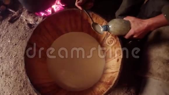 手拿勺子加入牛奶酶加速发酵视频的预览图