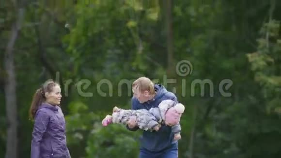 幸福的家庭爸爸妈妈和小女孩在秋天公园散步户外玩耍视频的预览图