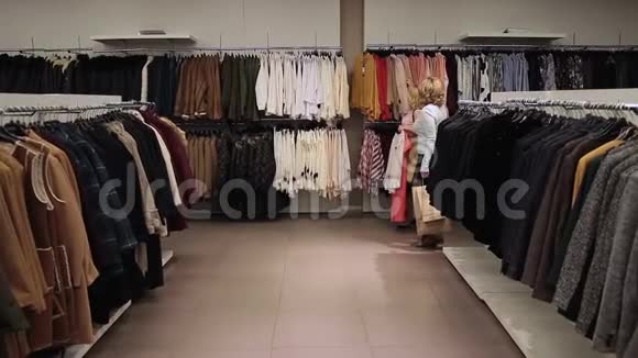 美丽的购物狂女人在商店里买衣服视频的预览图