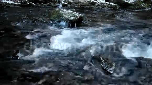 河岸和冰冷清澈的溪流中的大砂岩巨石视频的预览图