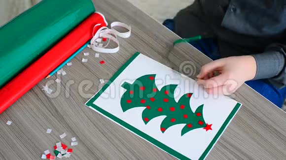 青少年男孩用彩色自粘纸制作圣诞卡视频的预览图