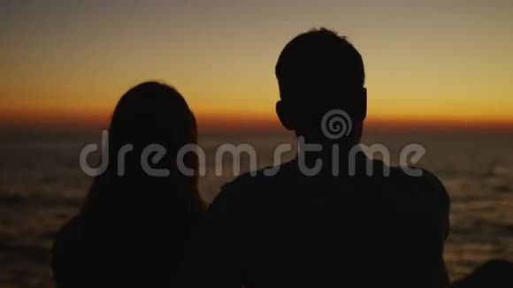 日落时海边的浪漫情侣视频的预览图