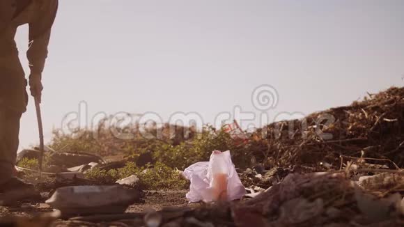 一个肮脏的流浪汉在垃圾堆里吃食物在包裹里找食物走路去找视频的预览图