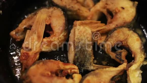 一片淡水鱼在铸铁锅中煎炸视频的预览图
