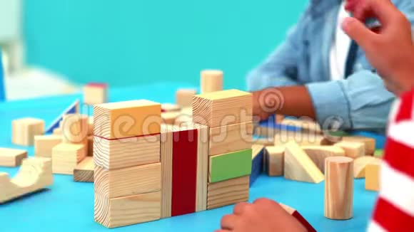 可爱的小男孩在桌子上玩积木视频的预览图