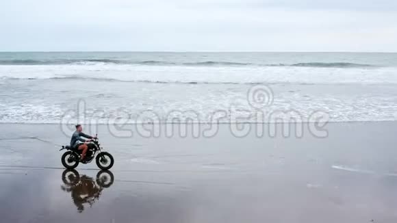 在海滩上骑摩托车的人巴厘岛海滩日落上的老式摩托车年轻的时髦男性享受自由视频的预览图