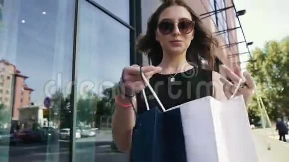 开朗的女人拿着她的购物袋慢动作视频的预览图