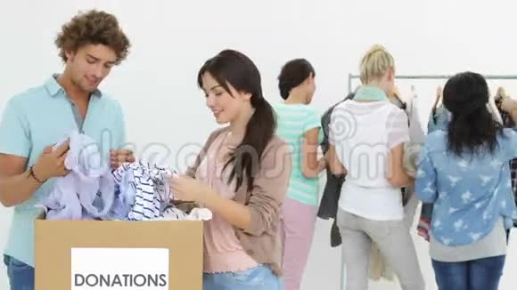 一群快乐的人穿过捐赠箱的衣服视频的预览图