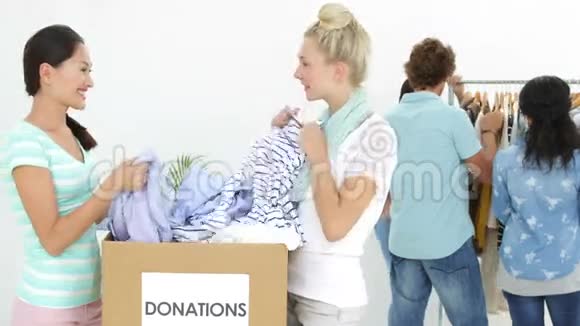 一队人穿过捐赠箱的衣服视频的预览图