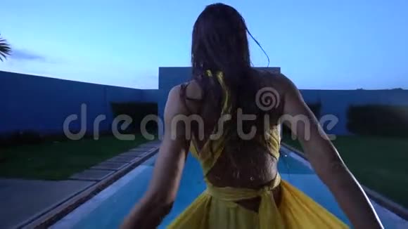 游泳池边穿着黄色连衣裙的美丽黑发女子视频的预览图