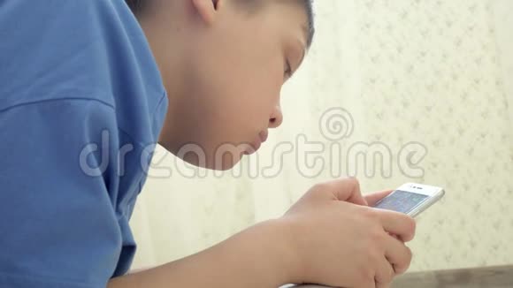 青少年在家中坐在地板上兴奋地玩智能手机游戏视频的预览图
