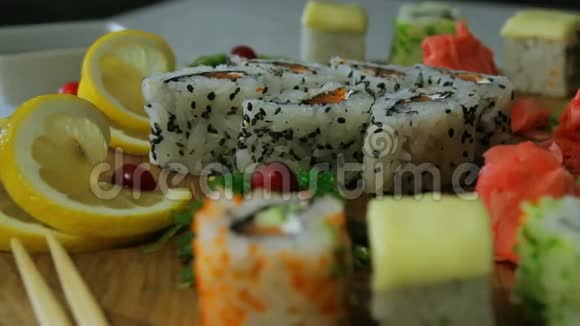 带有芥末和生姜的木制盘子里有美味的寿司卷视频的预览图