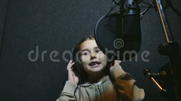 少女耳机唱入麦克风专业录音室音乐视频的预览图