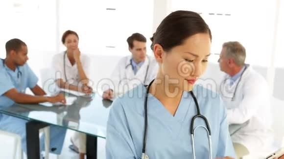 快乐的护士看着镜头后面有工作人员视频的预览图
