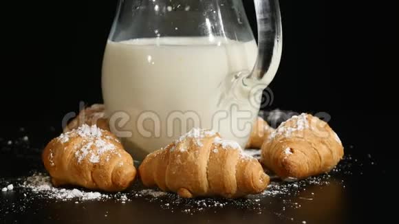 牛角面包牛奶在黑色背景上旋转视频的预览图