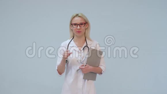 穿着白色外套和听诊器微笑着看镜头的女医生视频的预览图