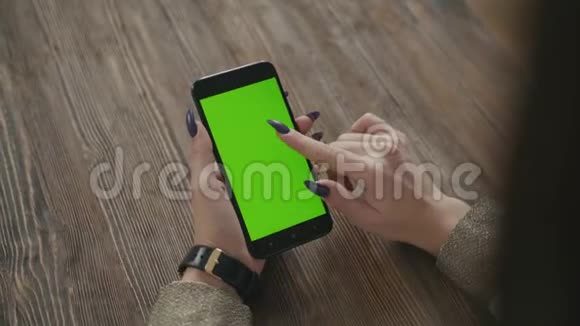 美丽的女孩手里拿着智能手机手里拿着绿色的屏幕视频的预览图