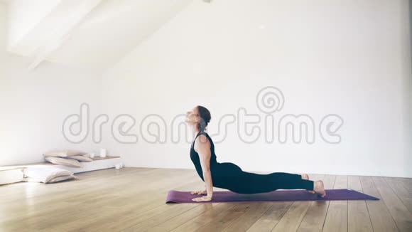 美丽的白人女性在室内做瑜伽侧视视频的预览图