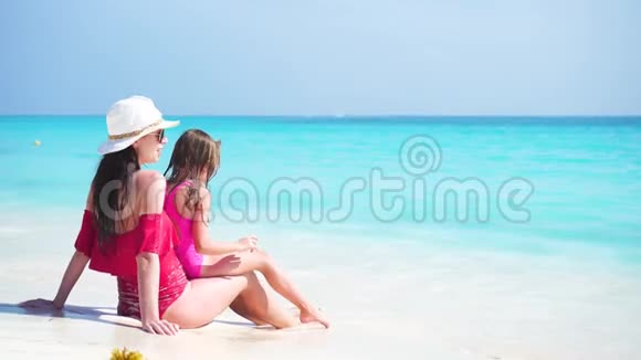 可爱的小女孩和年轻的母亲在热带海滩享受他们的海上假期视频的预览图
