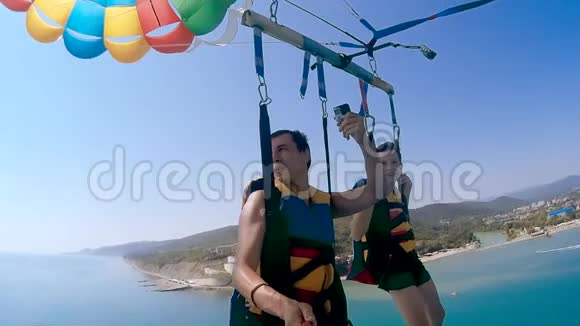 滑翔伞和海洋滑翔伞的生活方式男人和男孩正在海上乘降落伞飞行极限运动视频的预览图