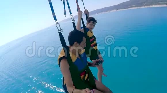 滑翔伞和滑翔伞的生活方式人类和男孩正在海上乘降落伞飞行极限运动视频的预览图