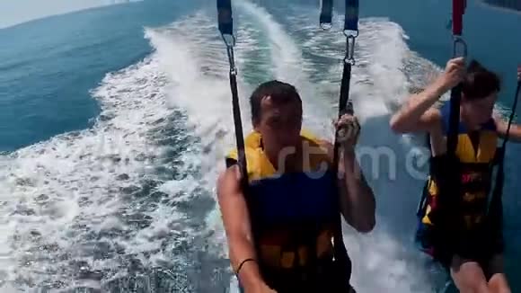 滑翔伞和滑翔伞的生活方式男人和男孩正在海上乘降落伞飞行海上极限运动视频的预览图