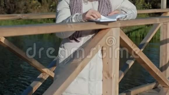 秋河附近的桥上的女人读一本书视频的预览图