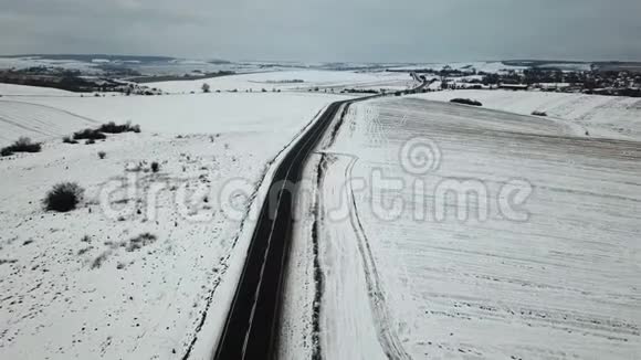 从空中观看冬季道路上的车辆行驶的场地视频的预览图