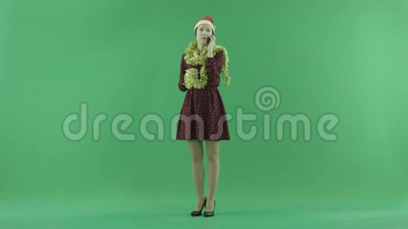 一位年轻的圣诞女士在绿色屏幕上用手机说话视频的预览图