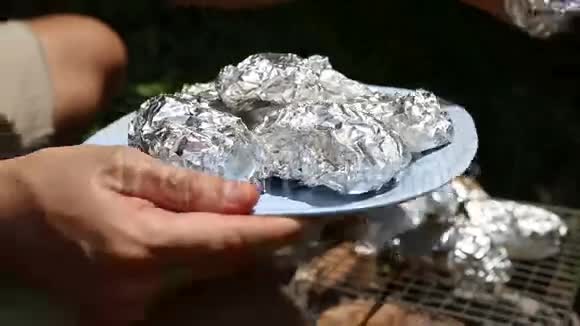 烤土豆在烤架上烤成箔状视频的预览图