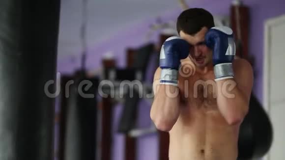 肌肉发达的男性职业拳击手训练在健身房的拳击袋裸胸手套视频的预览图