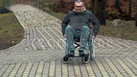 残疾人乘坐轮椅在户外行走视频的预览图