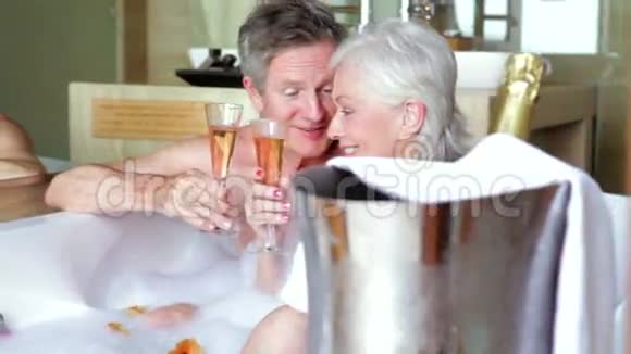 高级夫妇在沐浴中放松喝香槟视频的预览图