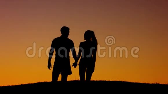 恋爱中的情侣在夕阳的背景下散步视频的预览图