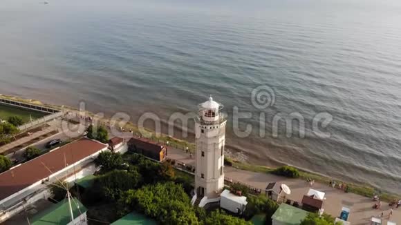 飞过靠近大海的海岸悬崖上的灯塔空中射击视频的预览图