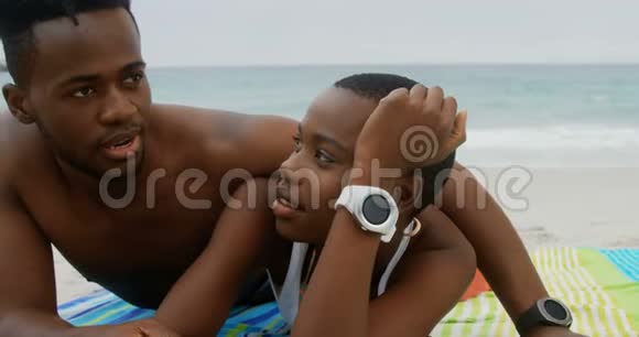 在海滩放松的非裔美国人夫妇的正面景色视频的预览图