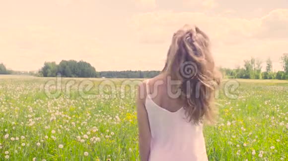 年轻女子走在草地上视频的预览图