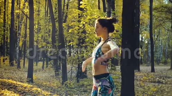 秋天森林里做运动的年轻美女视频的预览图