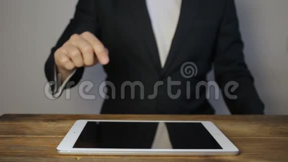 做全息界面的商人穿着夹克的男人触摸视觉屏幕平板电脑上的白色图标视频的预览图
