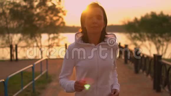 运动女性在日落时慢跑视频的预览图