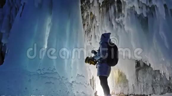 在贝加尔湖冰洞旅行的女人去冬岛旅行女孩背包客正在冰窟散步旅行者看起来视频的预览图