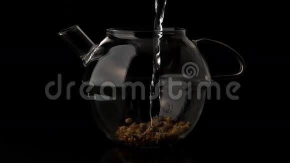 水倒在玻璃茶壶上倒在松散的草药茶上视频的预览图
