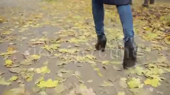 穿过树叶的女人秋天公园视频的预览图