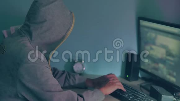 在电脑上工作的男性黑客黑客隐藏在室内他的脸上网视频的预览图