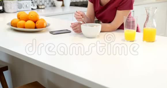 美丽的女人用手机吃早餐视频的预览图