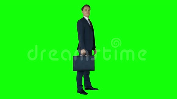 站在绿色屏幕上的商人带着手提箱视频的预览图